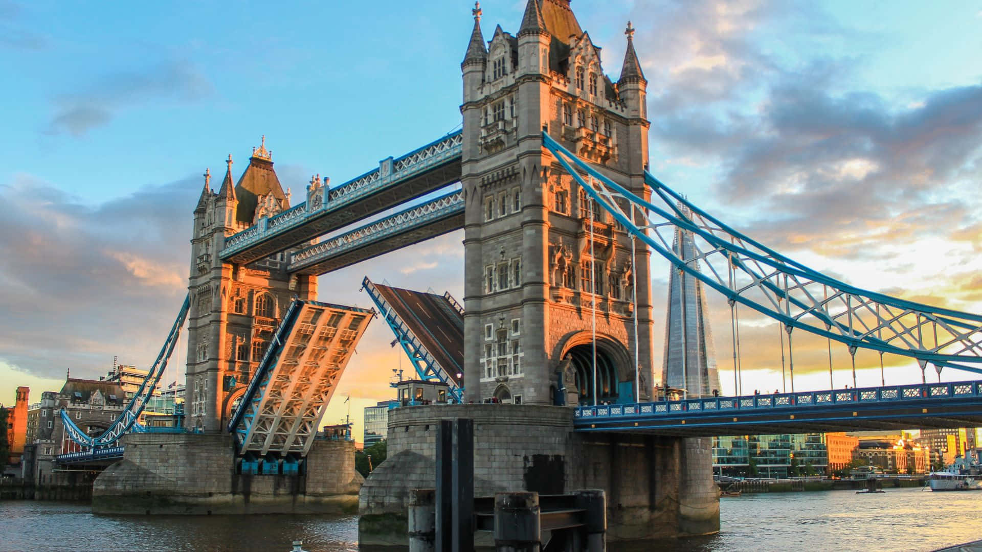 UK 桌布 壁紙 — 倫敦的塔橋在日落時分雄偉地升起，其開合橋升起，天空染上溫暖的金色色調。
