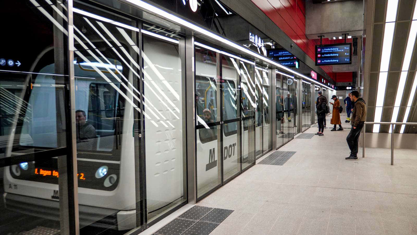 乘客在現代地鐵站等候，列車抵達時帶有玻璃門。