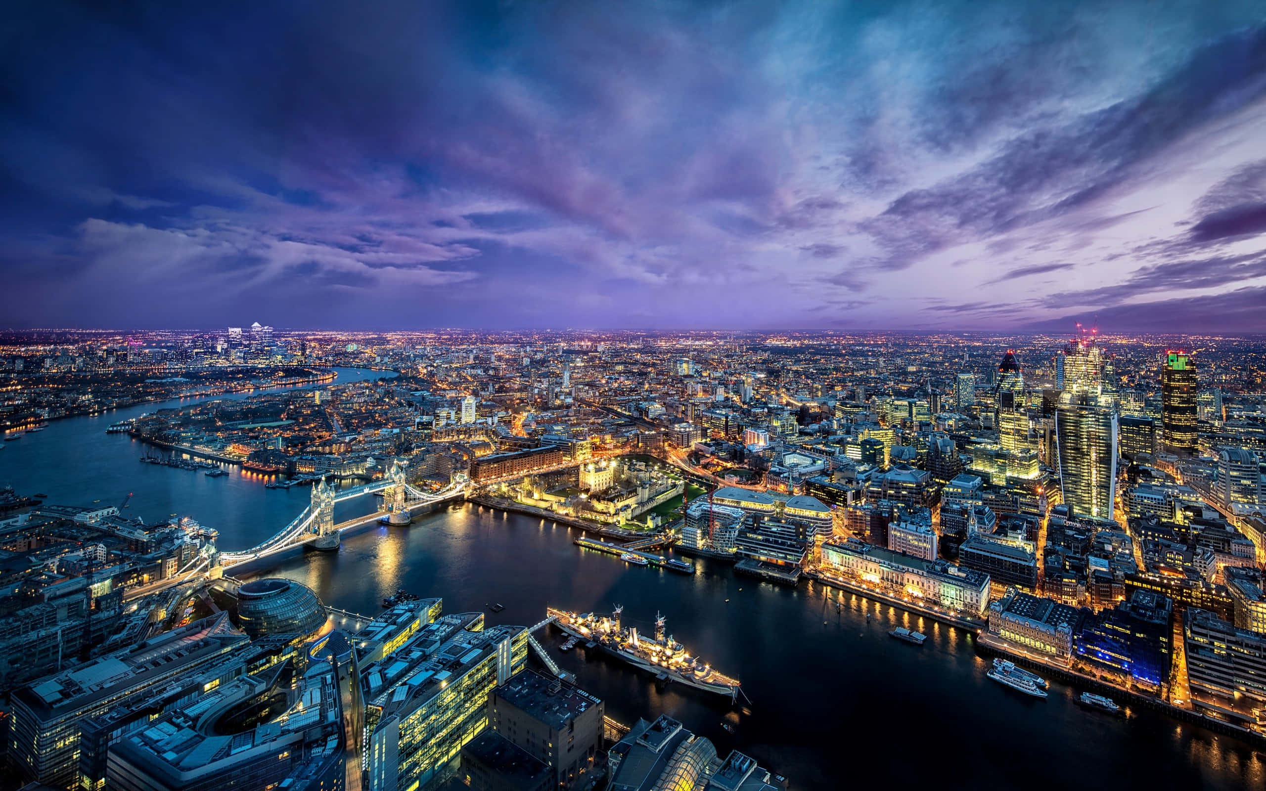 England 桌布 壁紙 — 倫敦黃昏時的鳥瞰圖，塔橋在戲劇性的紫色天空下亮起。