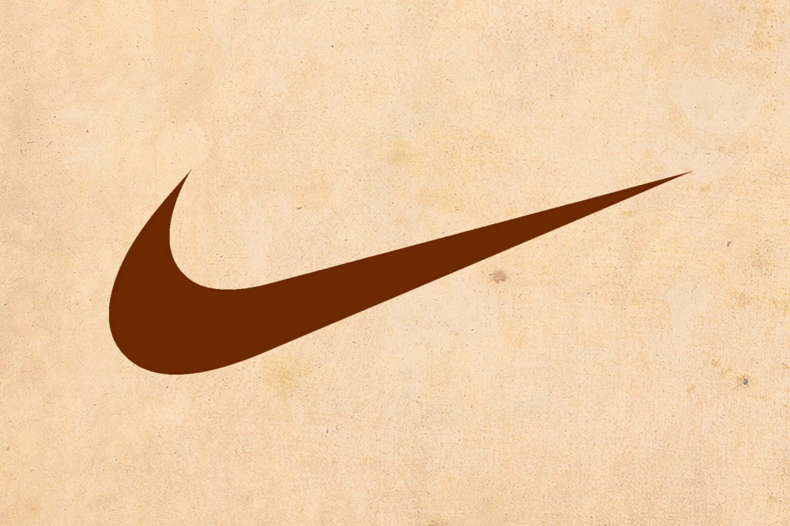 棕色Nike swoosh標誌在紋理米色背景上。