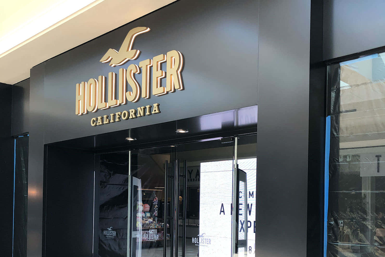 Hollister California商店正面，配有玻璃門和金色標牌。