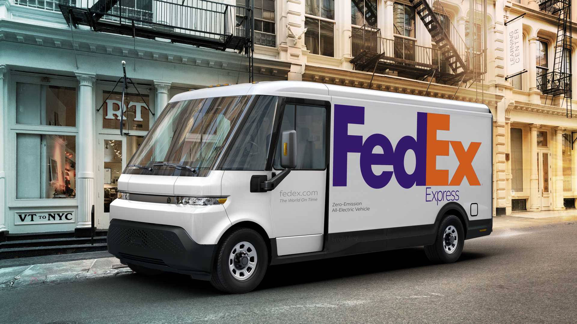 白色FedEx電動送貨車停泊在歷史建築附近的城市街道上。