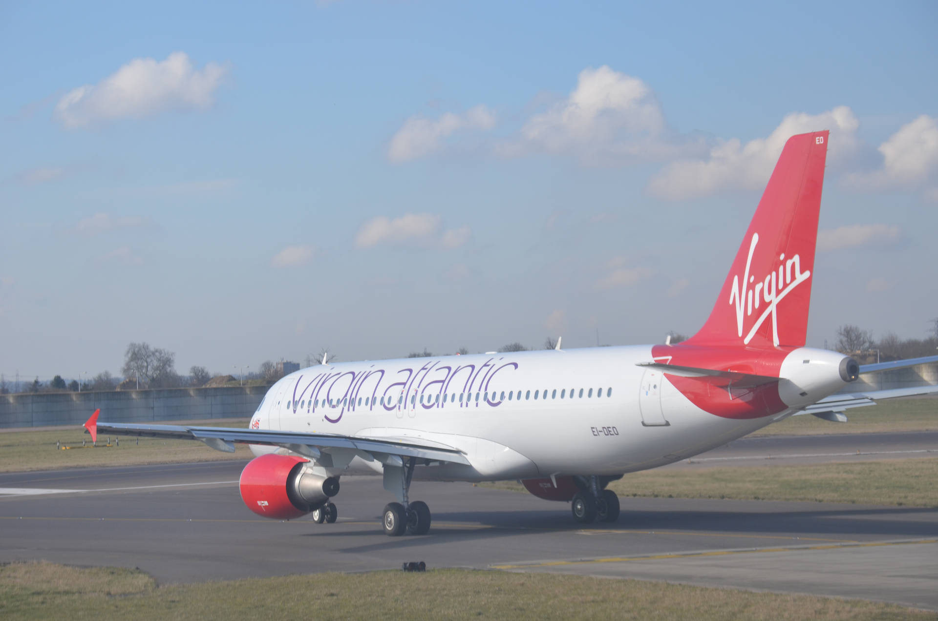 維珍航空飛機在跑道上，紅色機尾和引擎