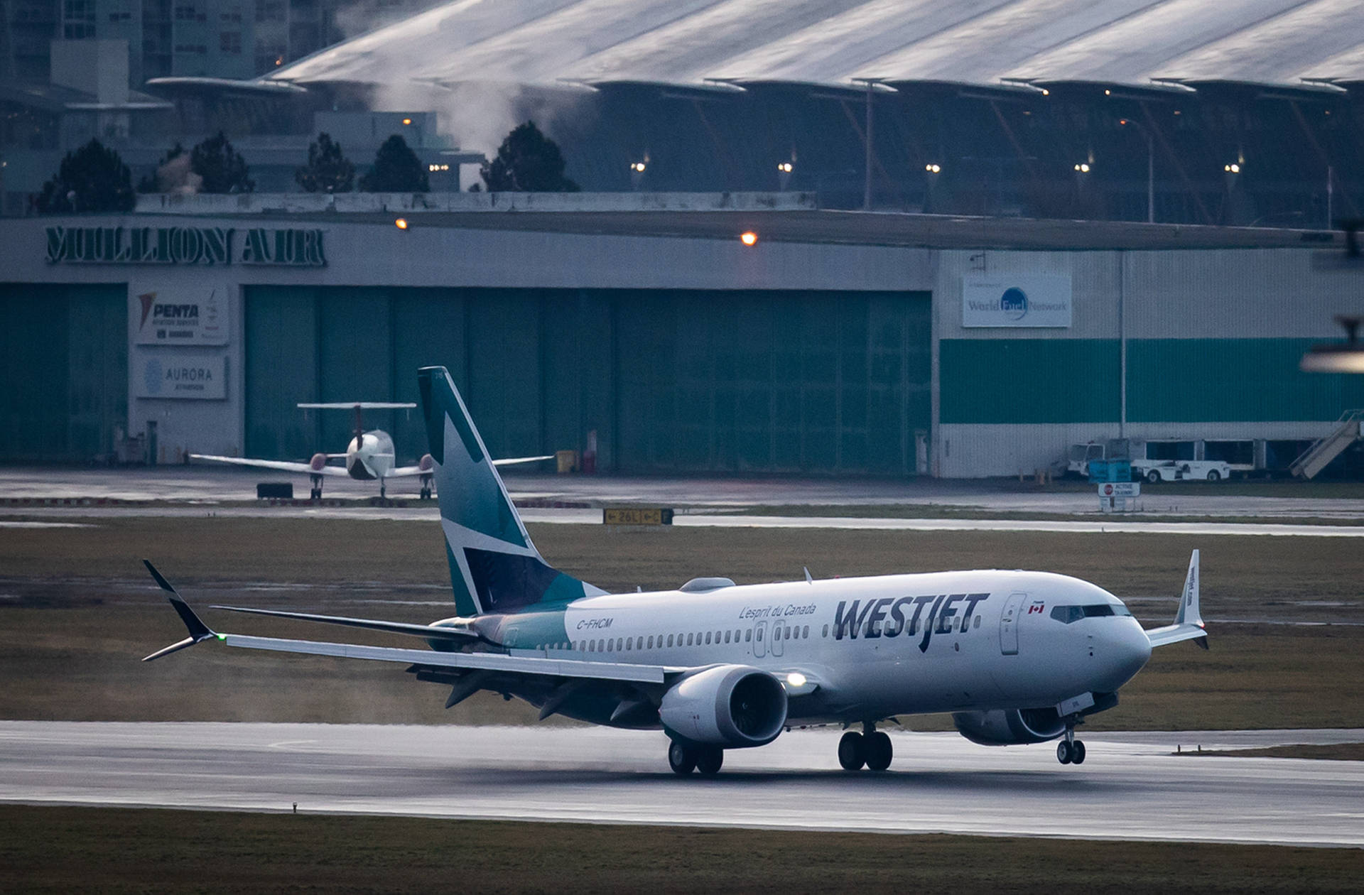 西捷航空飛機在黃昏時分在機場跑道上滑行