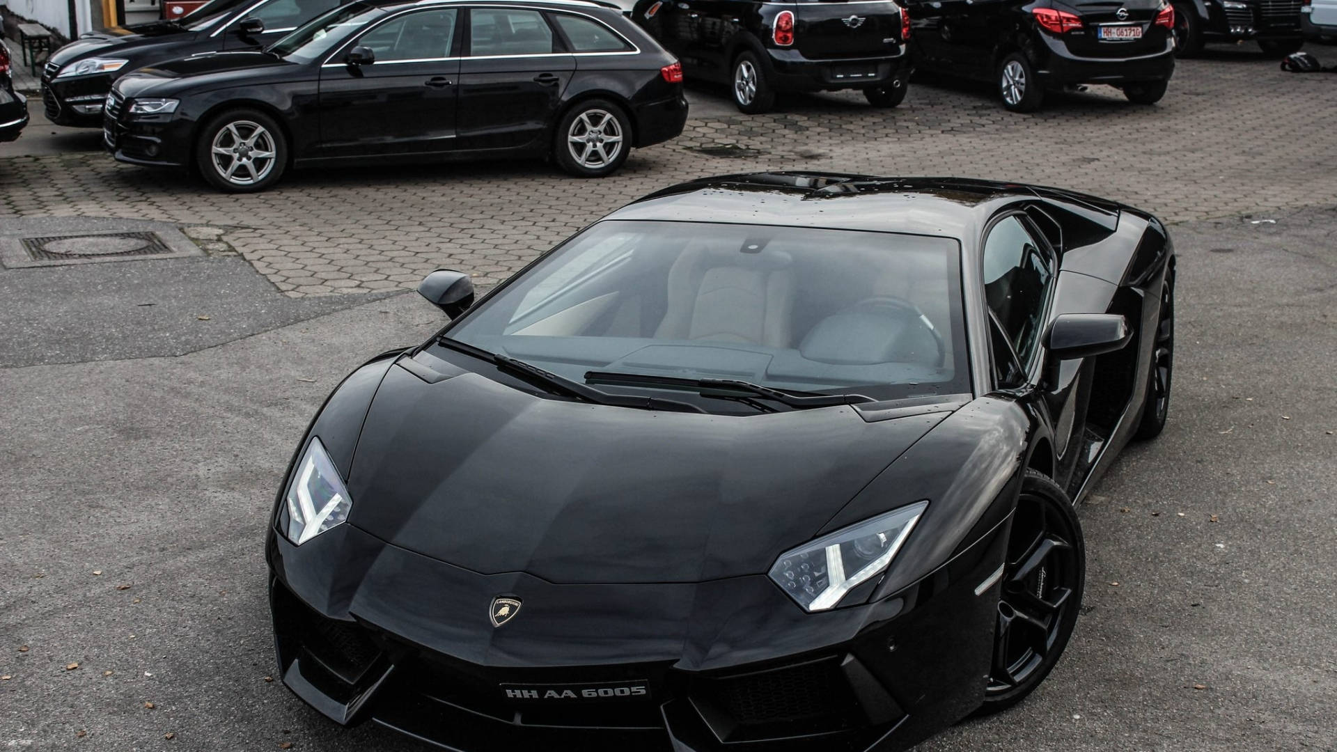 黑色林寶堅尼Aventador停泊在停車場，與其他車輛一起。