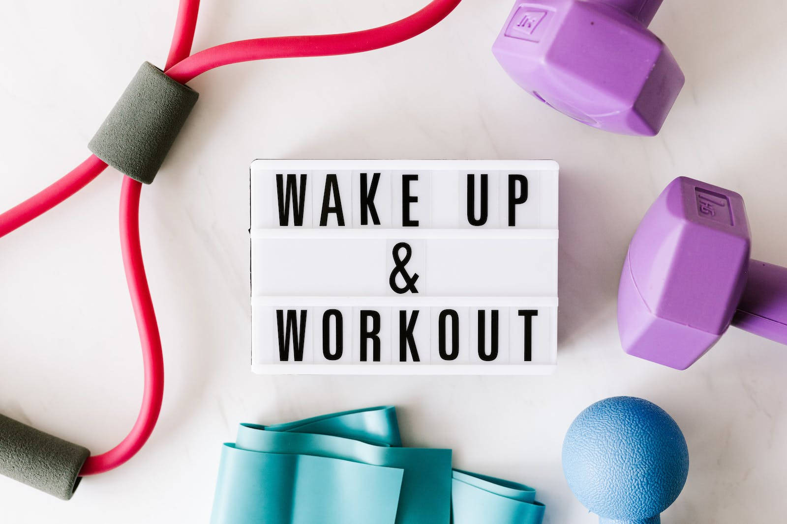 健身器材圍繞一個寫着wake up and workout的燈箱標誌排列。
