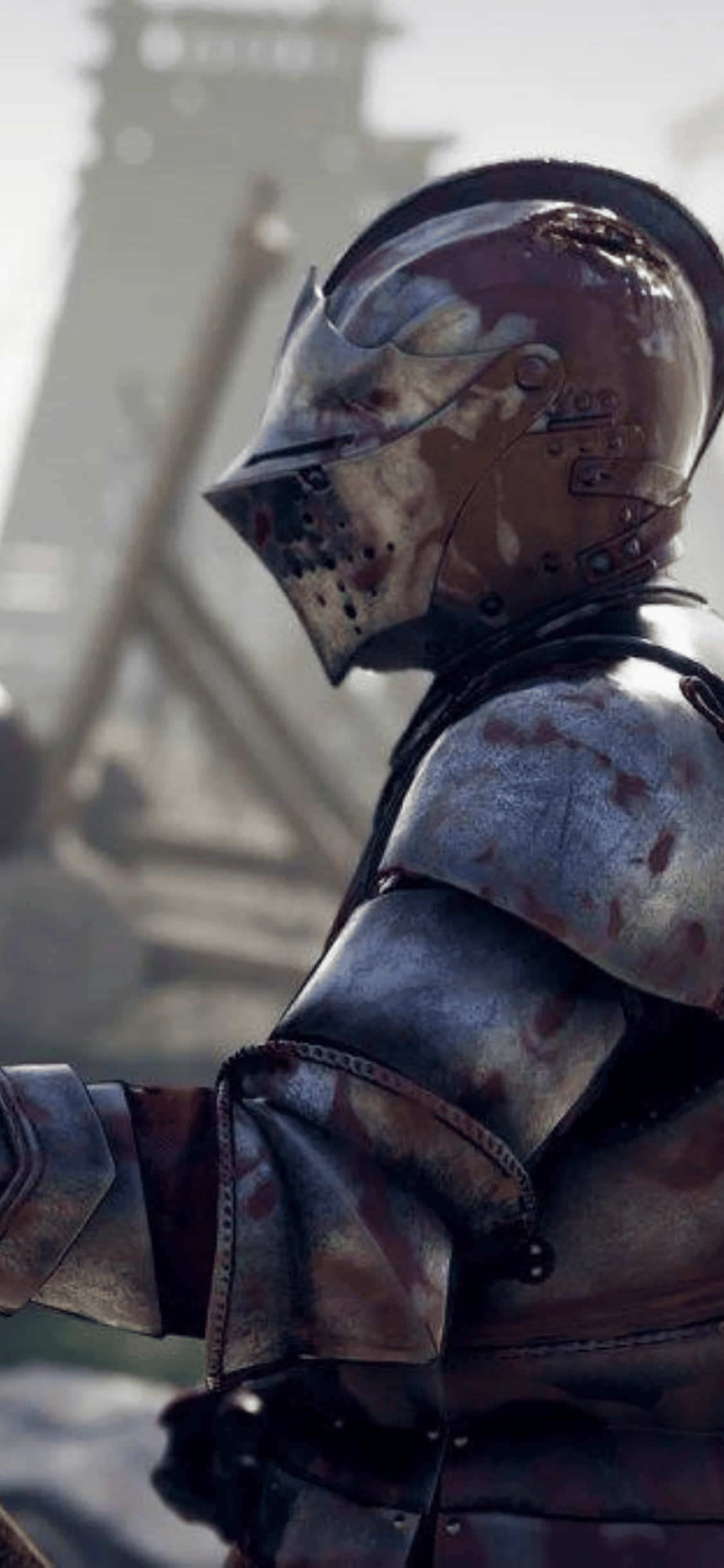 側面視角 iPhone XS Mordhau 背景 壁紙 — 一位身穿鏽蝕盔甲的風化騎士，站在荒涼的廢墟中，遠處有一座塔樓，光線朦朧。