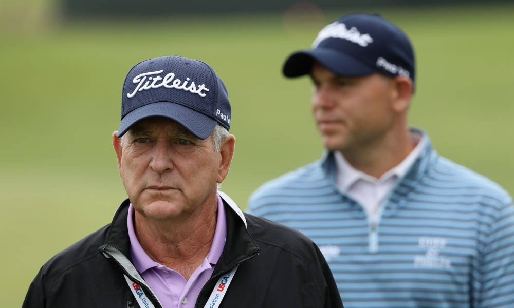 傑伊·哈斯戴Titleist高爾夫帽出賽 壁紙 — 兩名戴著 Titleist 帽子的高爾夫球手站在綠色球場上，一個在前景對焦，另一個在後面模糊。