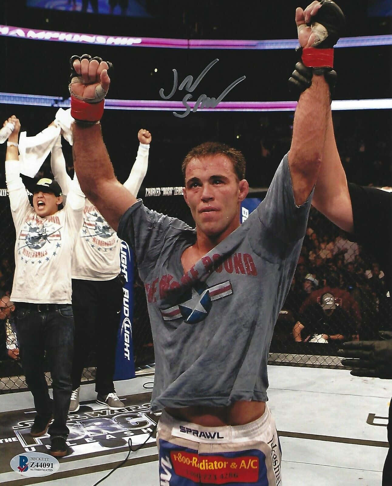MMA 拳手在八角籠中舉臂慶祝勝利。
