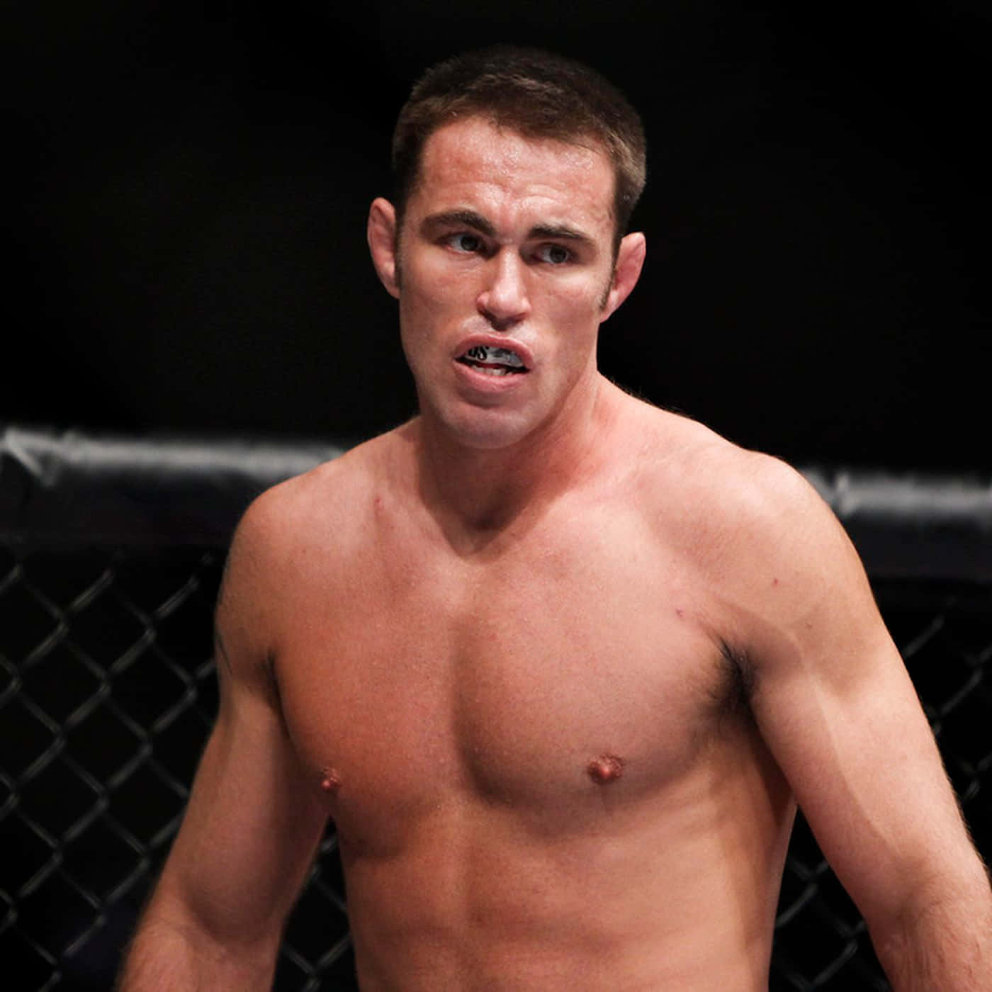 比賽期間，一名專注的男MMA拳手在籠內。