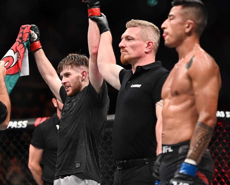 MMA拳手贏得比賽，裁判在八角籠中舉起他的手。
