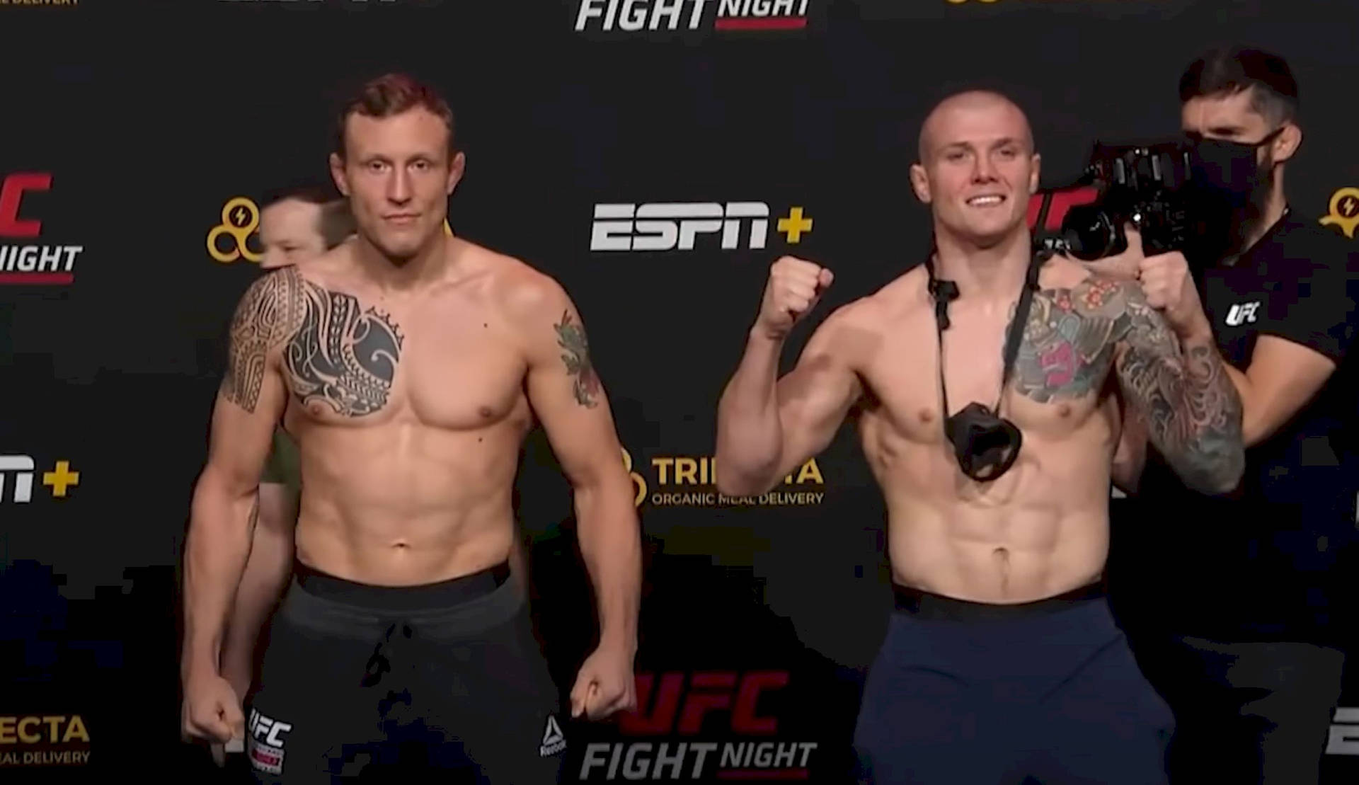 兩名有紋身、赤裸上身的MMA拳手在UFC稱重活動中擺姿勢。