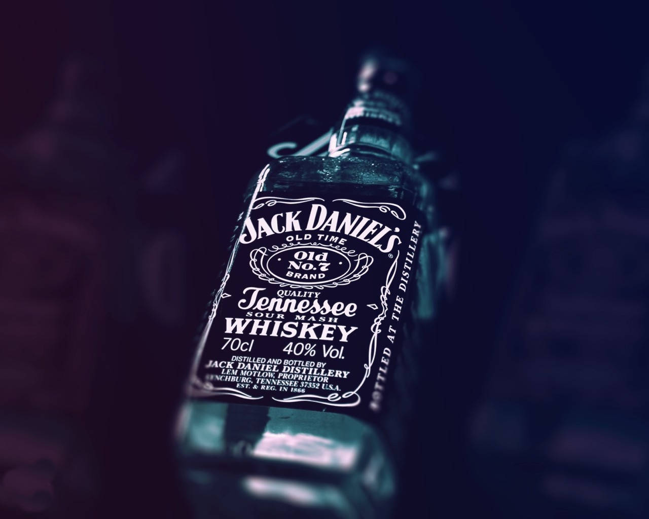 傑克丹尼士威士忌瓶展示 壁紙 — Jack Daniel's 威士忌酒瓶的特寫，帶有深藍色調和淺景深。