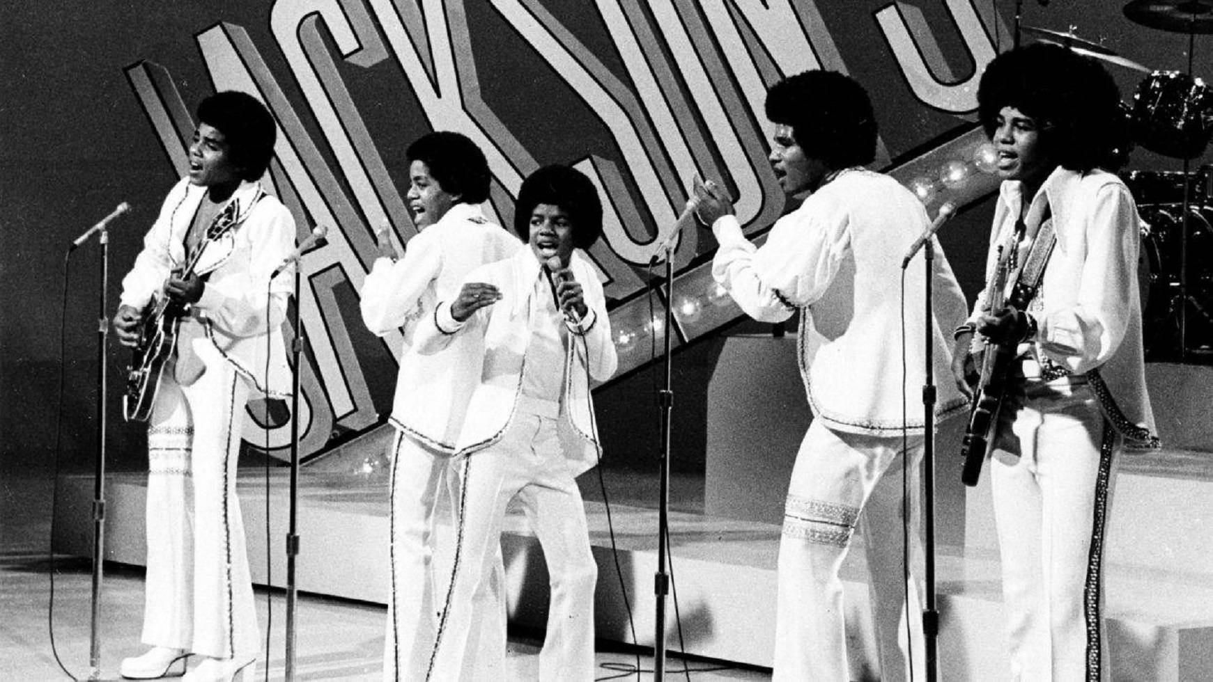 Jackson 5 穿著白色西裝在舞台上現場表演。