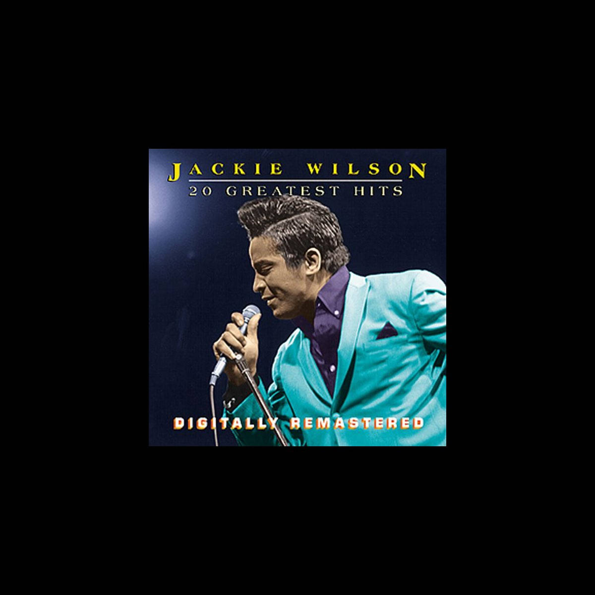 傑基·威爾遜美國歌手 壁紙 — Jackie Wilson 身穿青綠色西裝，在黑暗背景的舞台燈光下對著麥克風唱歌。