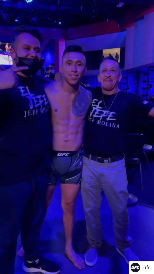 三名男子在藍色燈光下於UFC活動後台擺姿勢。
