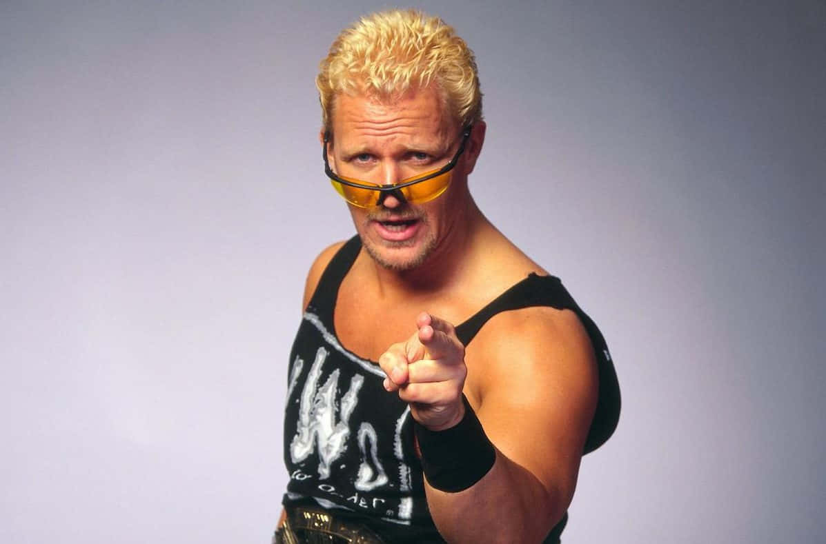 傑夫·賈雷特指向鏡頭 WWE 摔角手攝影 壁紙 — 一位肌肉發達的摔角手，有著尖刺金髮和黃色眼鏡，在純灰色背景前直接指向觀眾。