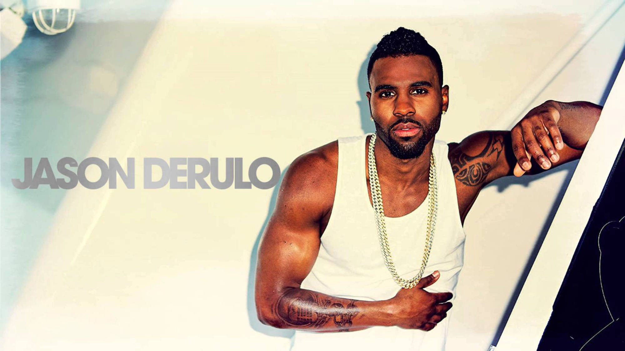 傑森·德魯羅白色造型 壁紙 — Jason Derulo 自信地靠在一艘時尚的白色遊艇上，身上有醒目的紋身和一條金鏈，在明亮的陽光下。