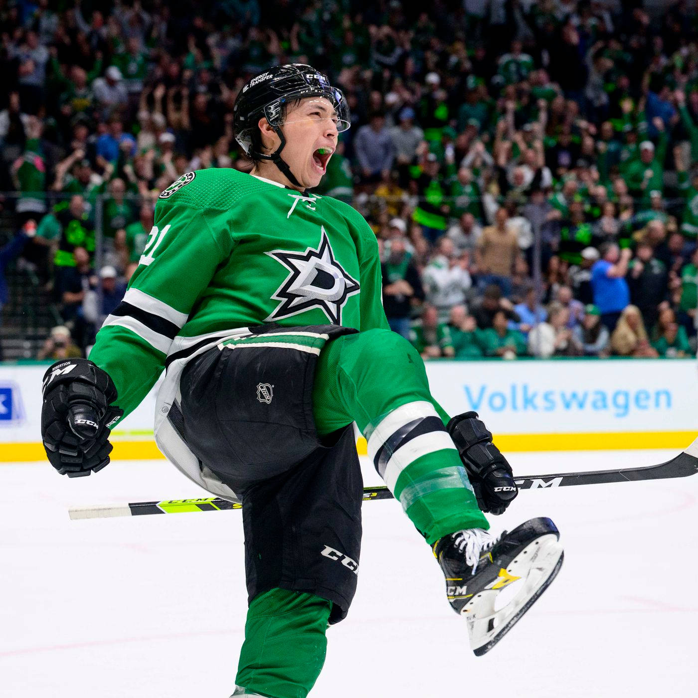 傑森·羅伯遜 Dallas Stars 勝場吶喊 壁紙 — 一名身穿綠色球衣的冰球運動員在冰上瘋狂慶祝，身後有群眾歡呼。