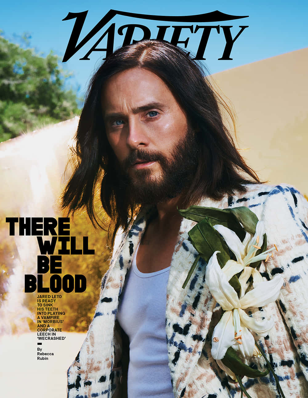 傑瑞德·雷托身著時尚服裝 壁紙 — Jared Leto 喺陽光普照嘅沙漠背景下，手持白色百合花，帶住「Variety」雜誌文字，凝視得十分專注。