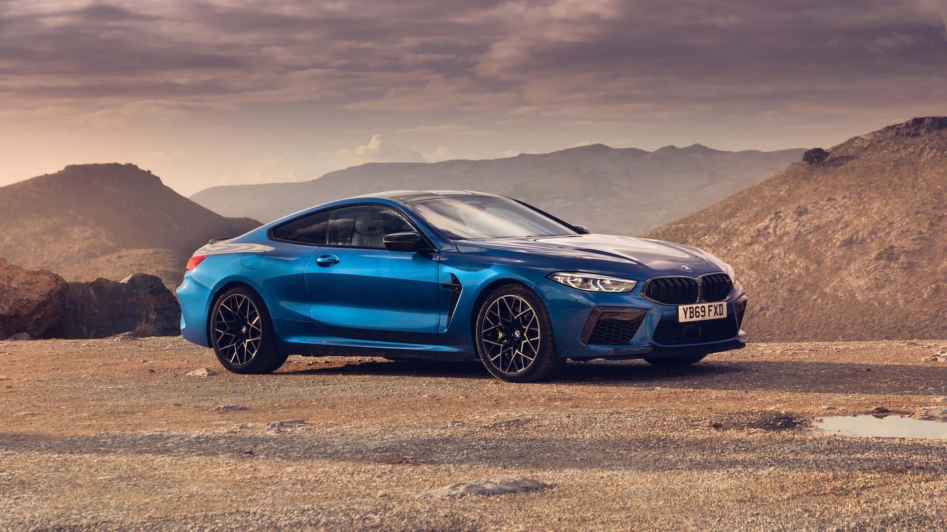 日落時分，藍色BMW M8 Coupe停泊在沙漠道路上。