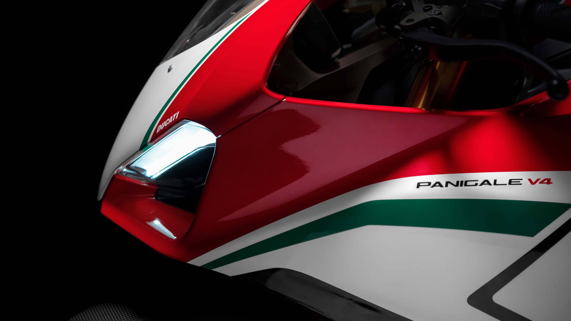 紅色、白色和綠色的Ducati Panigale V4電單車頭燈在黑暗中發光。
