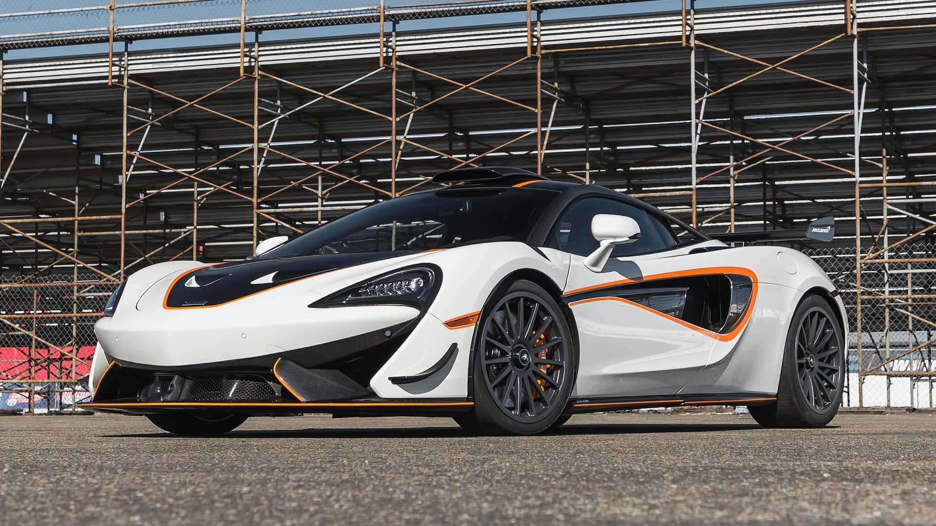白色McLaren跑車帶有橙色飾邊停在賽道上。