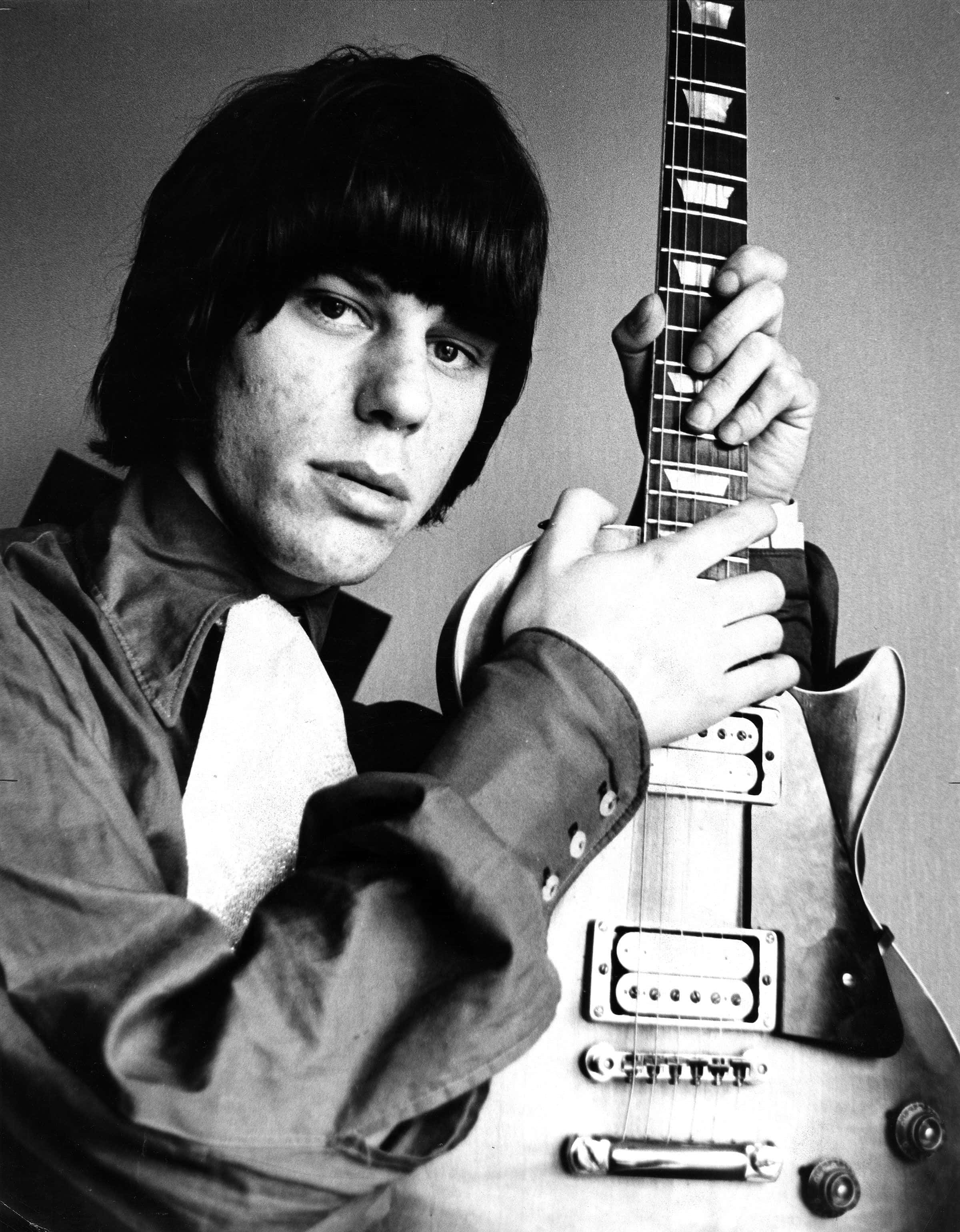 傳奇吉他手Jeff Beck與The Yardbirds演出 壁紙 — 一位深色頭髮的年輕男子在黑白工作室肖像中手持電結他。