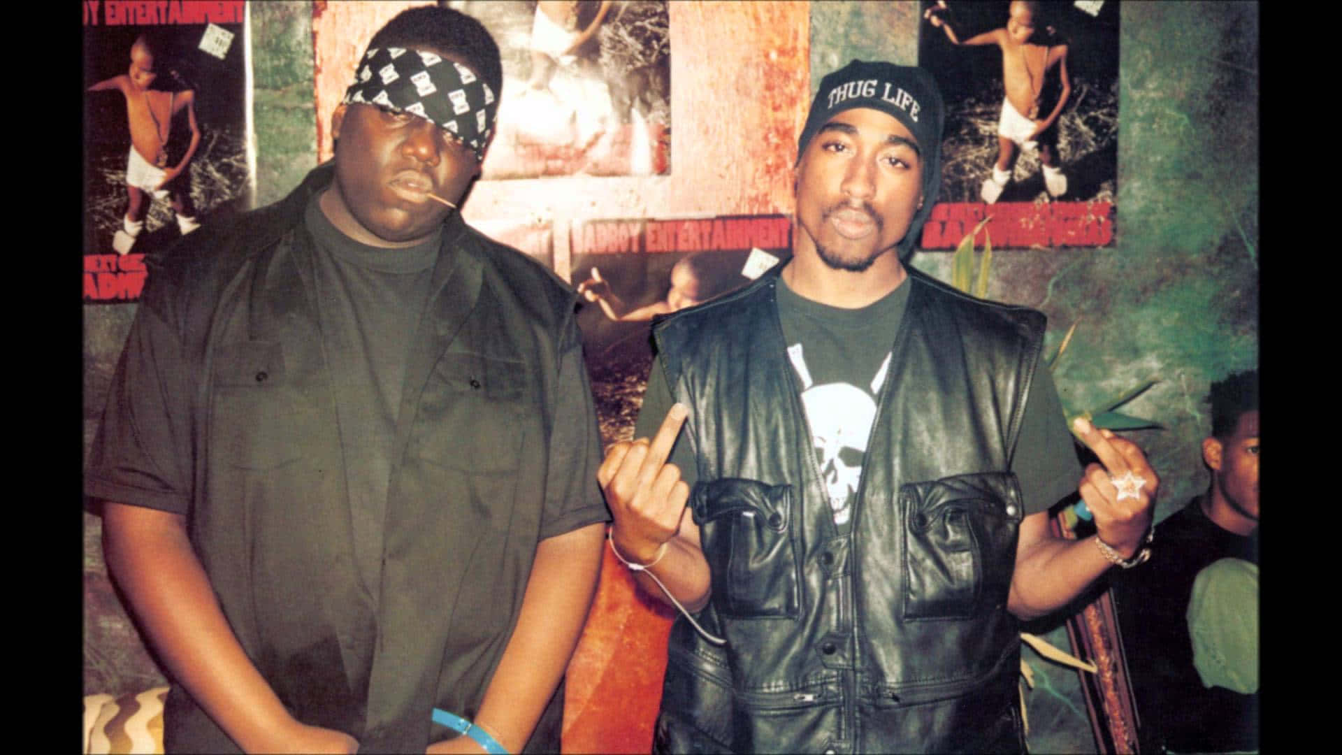 兩個穿著街頭服飾的男人在佈滿塗鴉的房間裡擺出有態度的姿勢。