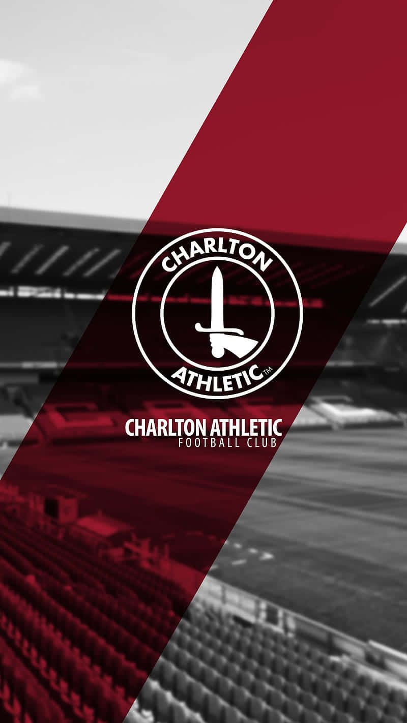 傳奇球員鮑比·查爾頓比賽瞬間 壁紙 — Charlton Athletic FC 標誌居中於一個對角分割的球場背景上，帶有紅色覆蓋層和黑白座位。