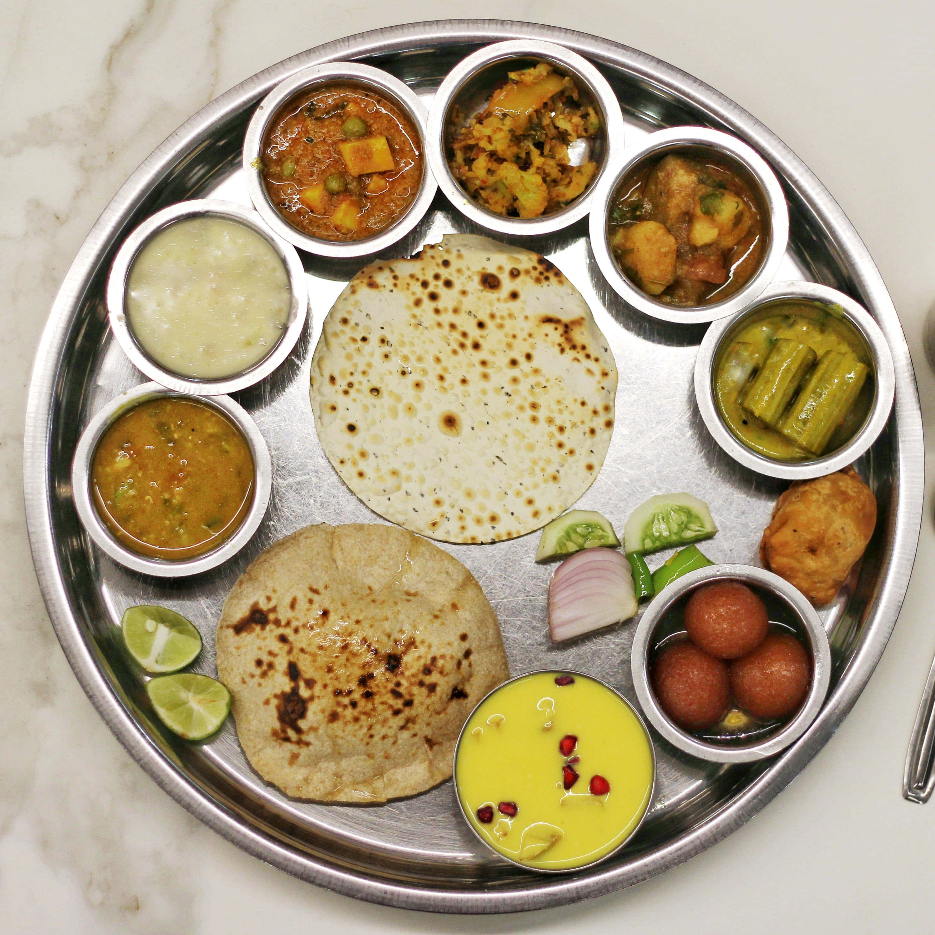 Thali 桌布 壁紙 — 傳統印度塔利，金屬盤上擺放著烤餅、咖哩、醃菜和甜點。