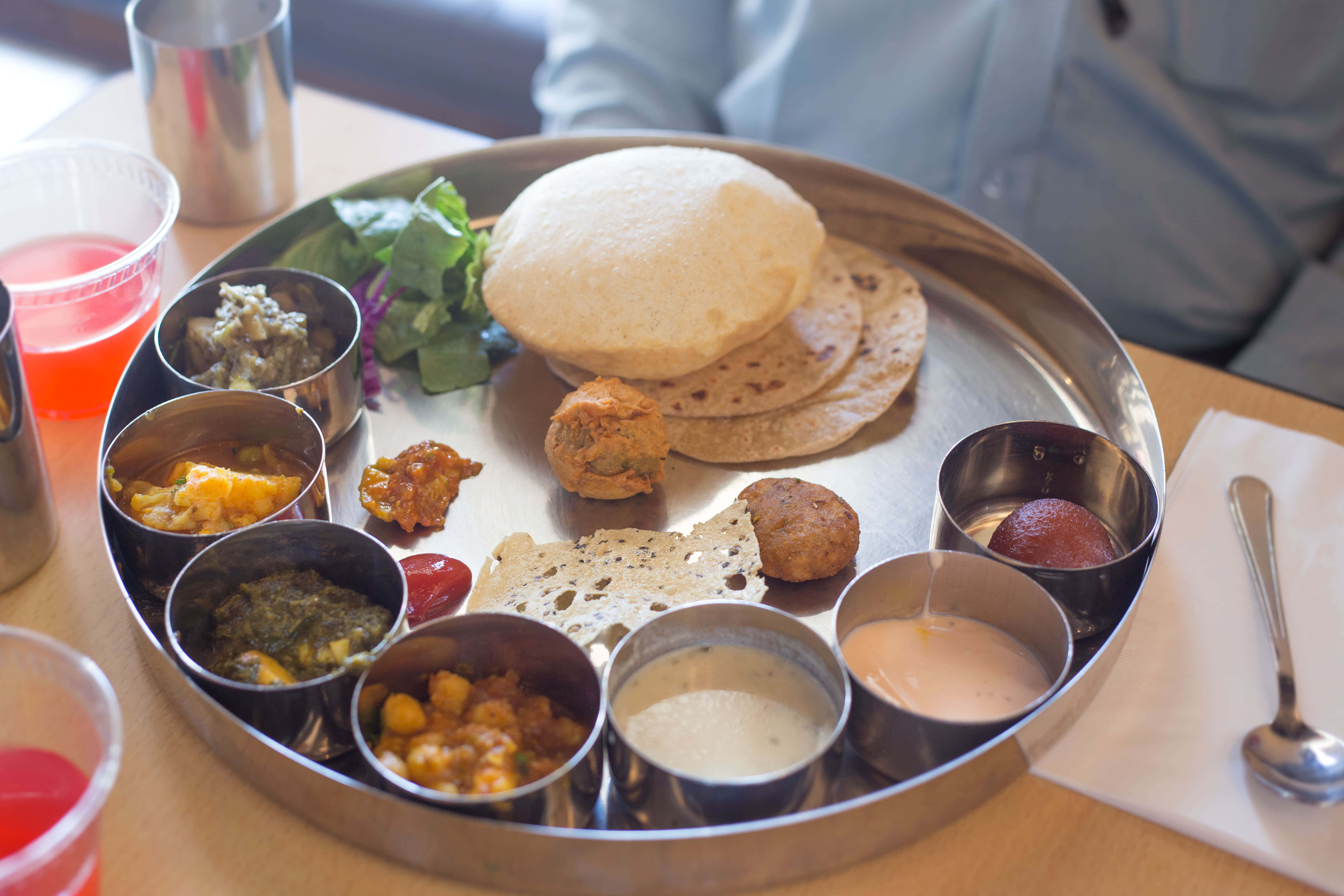 Thali 桌布 壁紙 — 傳統印度塔利餐，盛載於圓形金屬碟上，有多個小碗盛載色彩繽紛的咖喱、烤餅和酸辣醬。