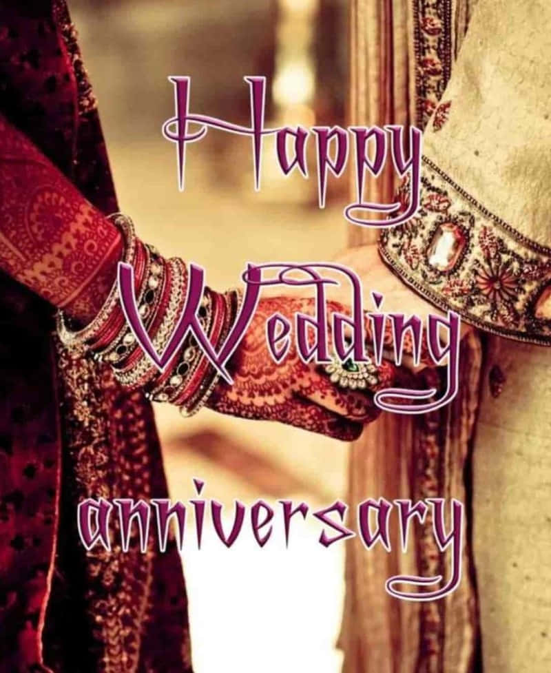 兩隻帶有指甲花和手鐲的手在結婚週年紀念日互相握住。