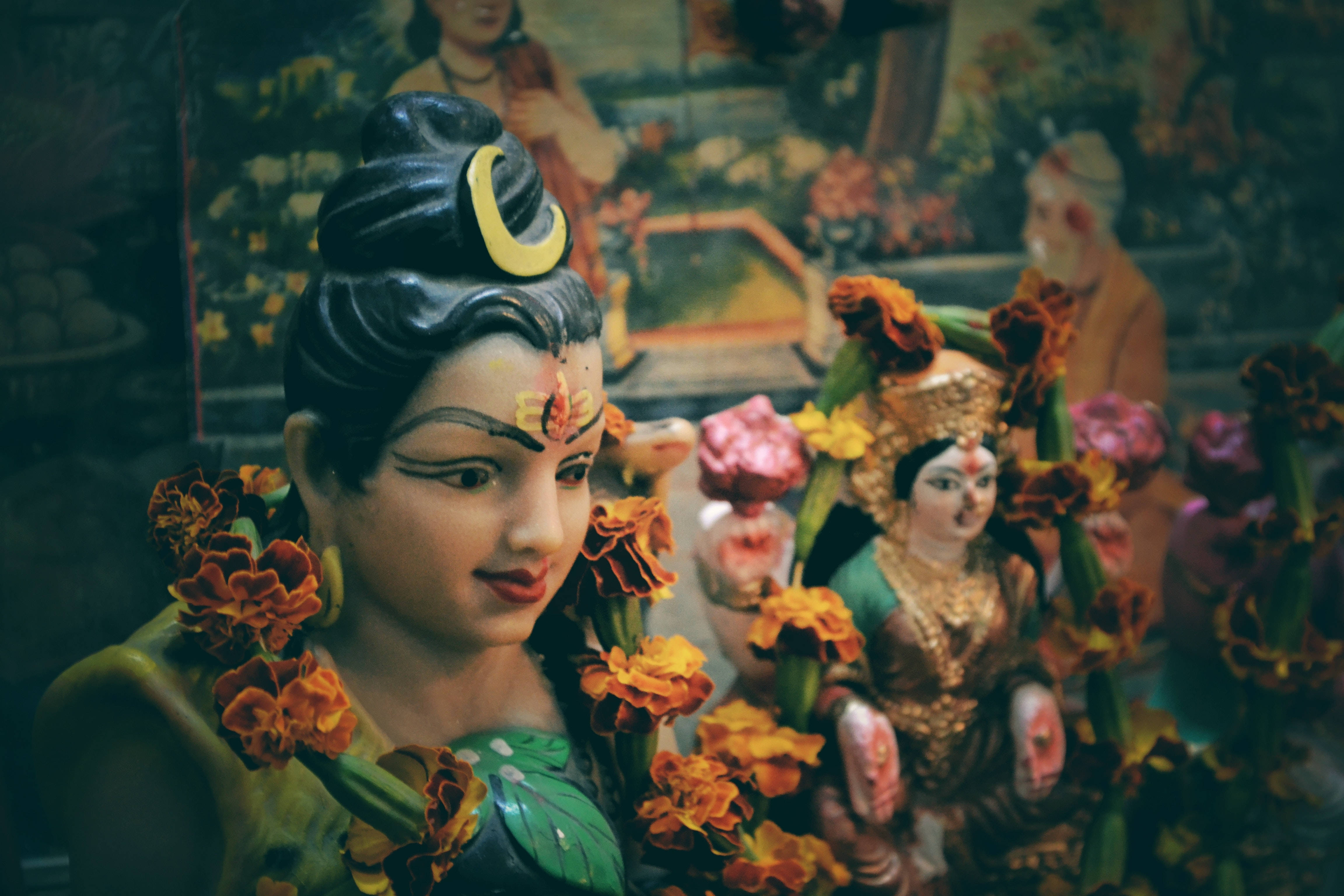 Lord Shiva 桌布 壁紙 — 傳統印度神像特寫，頭髮上裝飾著鮮豔的橙色萬壽菊和新月。