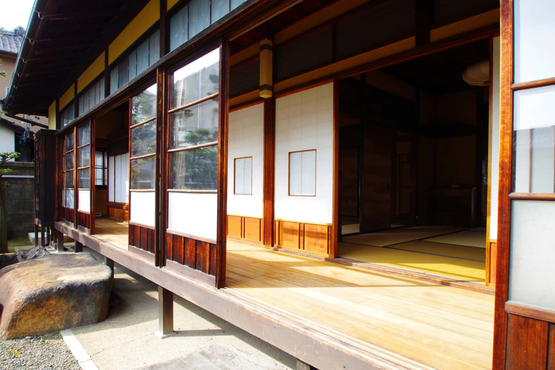 Japanese 桌布 壁紙 — 傳統日本木屋，配有滑動式障子門和榻榻米，沐浴在溫暖的陽光中。