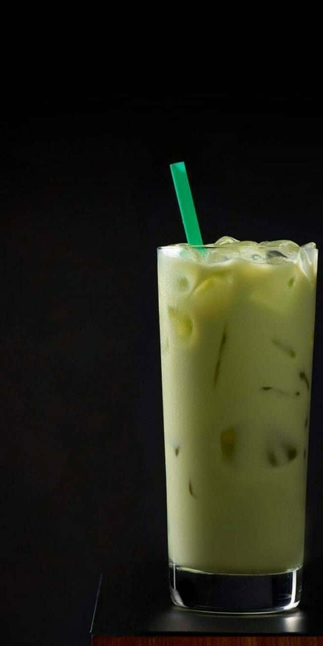 傳統碗中清爽抹茶 壁紙 — 一杯高身嘅忌廉冰抹茶拿鐵，有冰塊同綠色飲管，襯黑色背景。