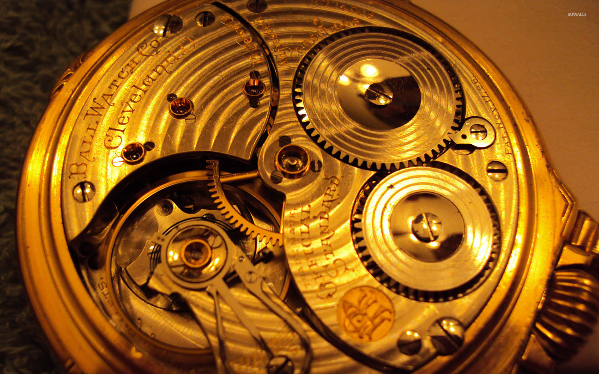 金色懷錶機芯，可見齒輪和刻字。