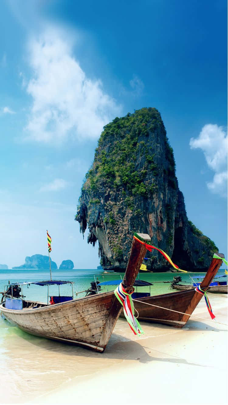 Thailand Beach 桌布 壁紙 — 傳統長尾船在明亮的藍天下，在叢林覆蓋的高聳石灰岩懸崖下的白色沙灘上休息。