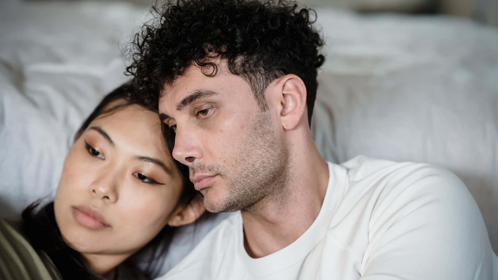 一男一女在安靜的親密中緊貼著在床上休息。