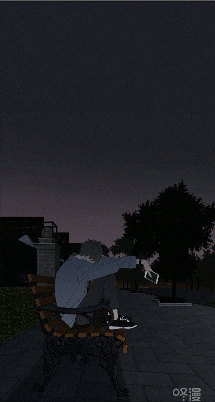 夜晚獨自坐在長椅上手持電話的人