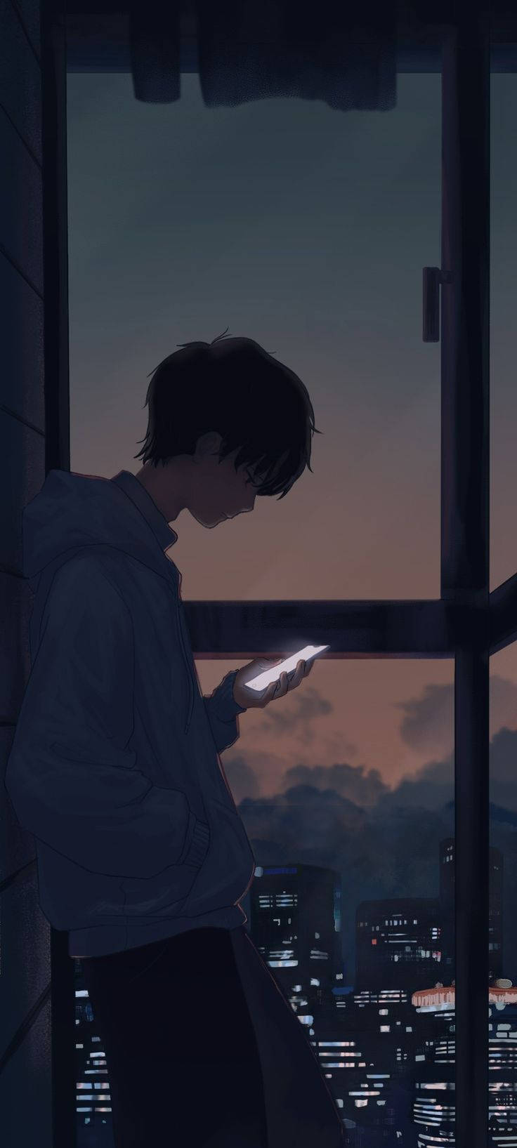 傷感動漫男孩手持手機 壁紙 — 一名穿著連帽衫的年輕男子在黃昏時分站在窗邊，手機的光芒映照著他，背景是城市天際線。