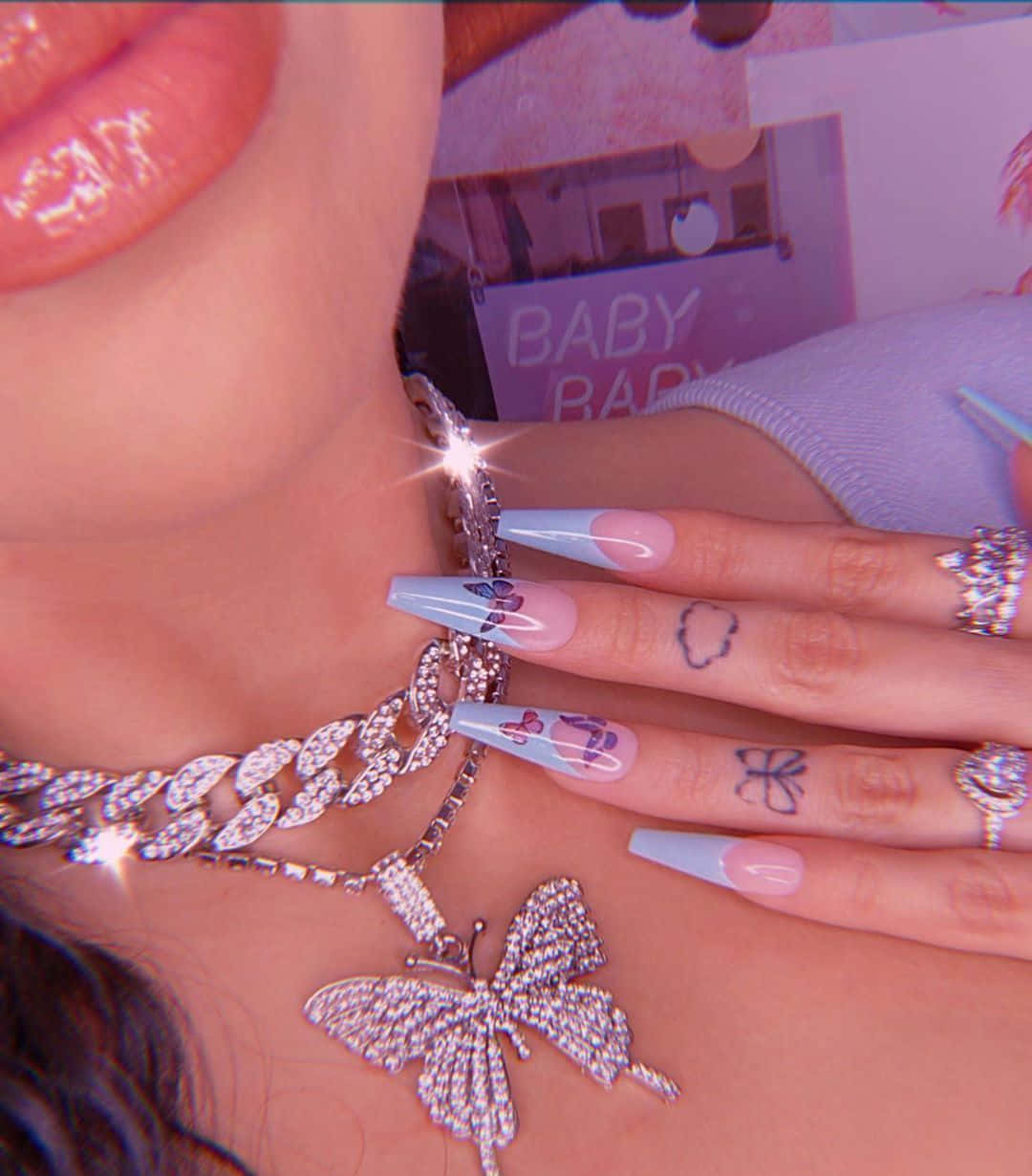 一個佩戴蝴蝶珠寶和蝴蝶主題指甲的人的特寫。 — Baddie 美學 壁紙