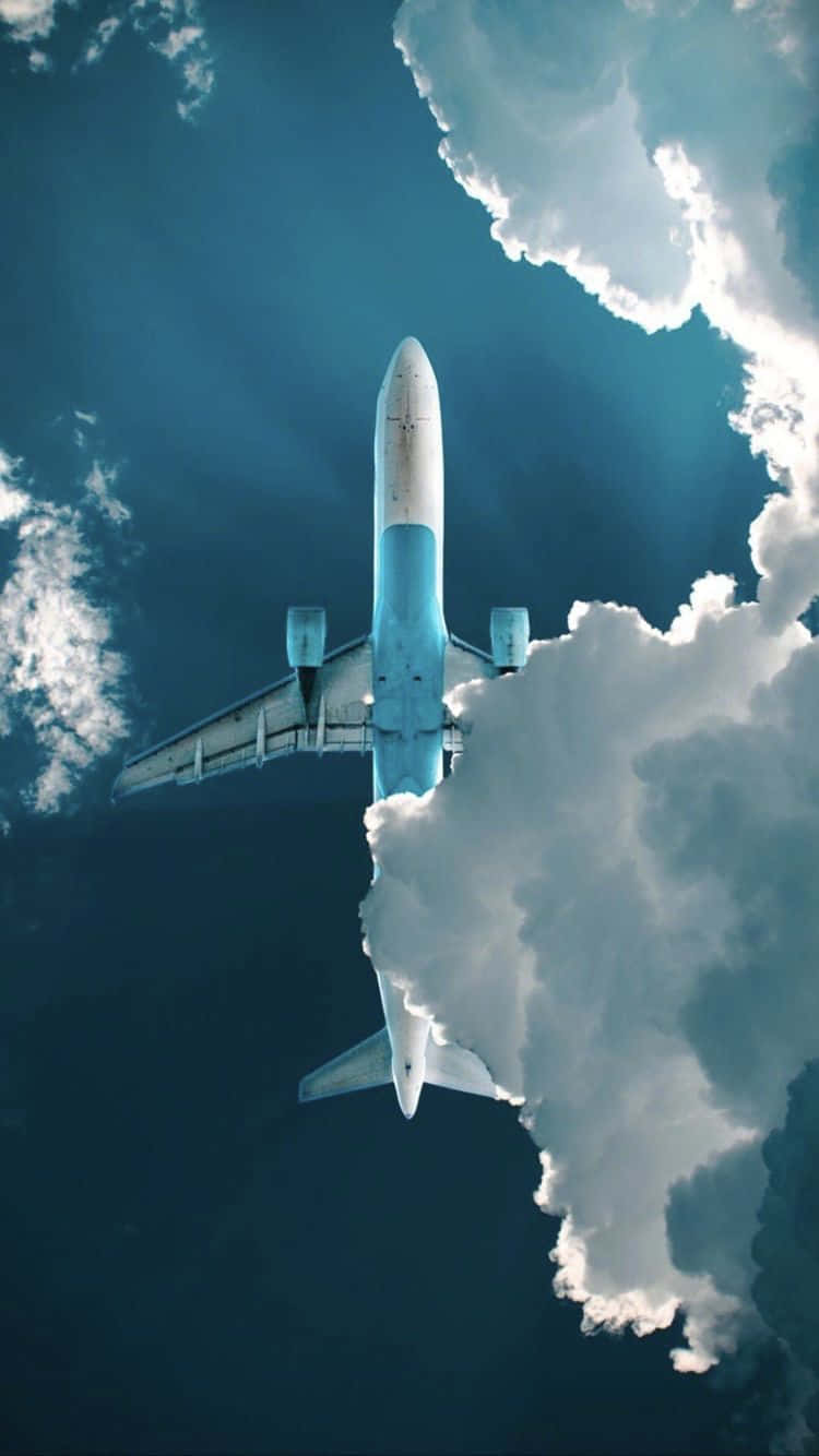一架白色飛機在深藍色天空中飛越蓬鬆的白雲。