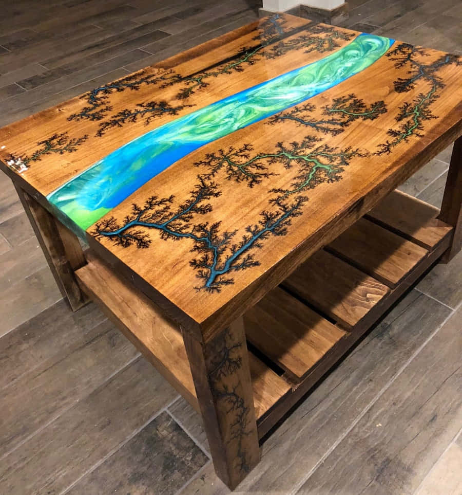優雅中置桌圖 壁紙 — 一張質樸的木桌，表面有充滿活力的藍綠色樹脂河流流過，並帶有黑色樹枝蝕刻。