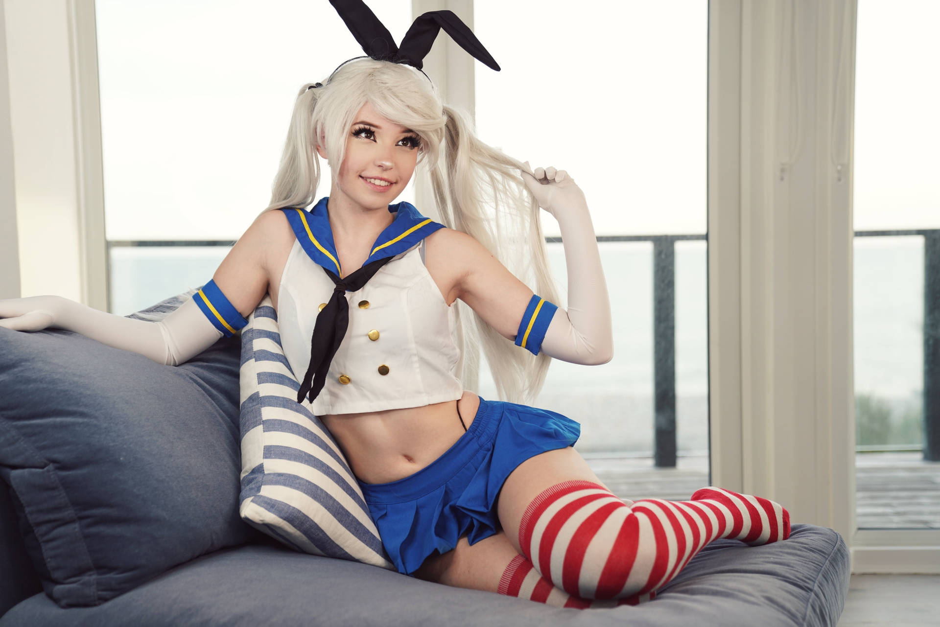 金髮女cosplayer穿水手服配兔耳，在窗邊沙發上躺臥。