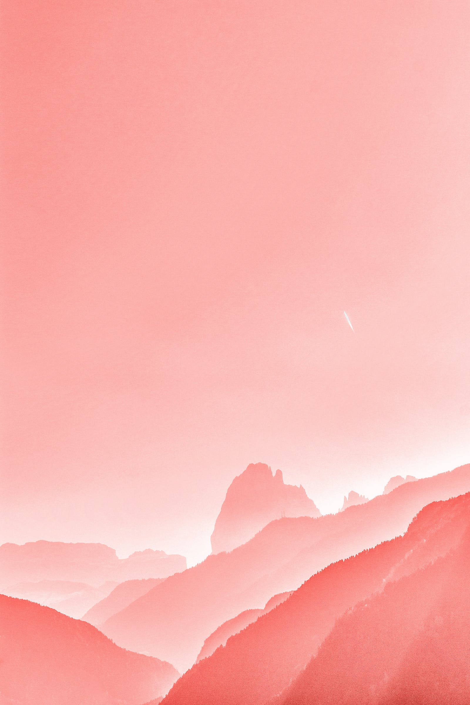 優雅柔和粉紅色山景 壁紙 — 粉紅色的山峰在柔和漸變的天空下逐漸消失在霧氣中，呈現寧靜的水彩風景。