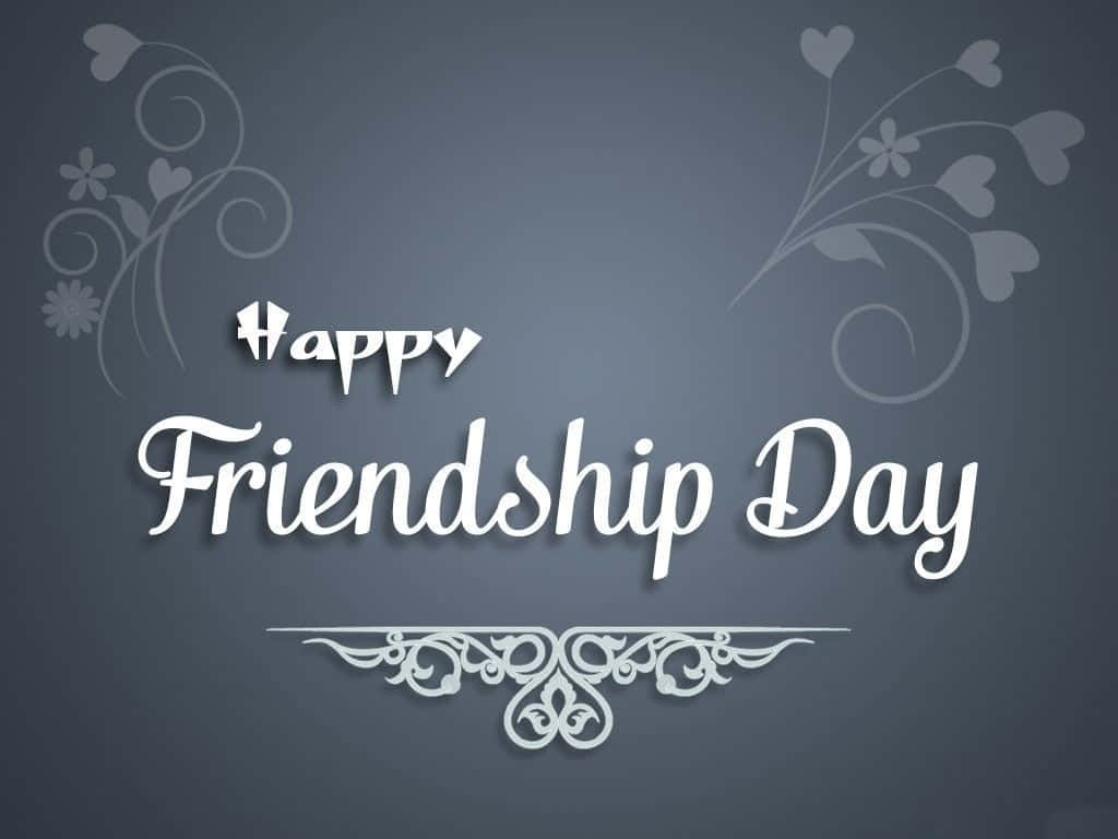 友誼日 桌布 壁紙 — 優雅的白色字體在深灰色背景上寫著「Happy Friendship Day」，背景點綴著精緻的花卉漩渦和心形圖案。