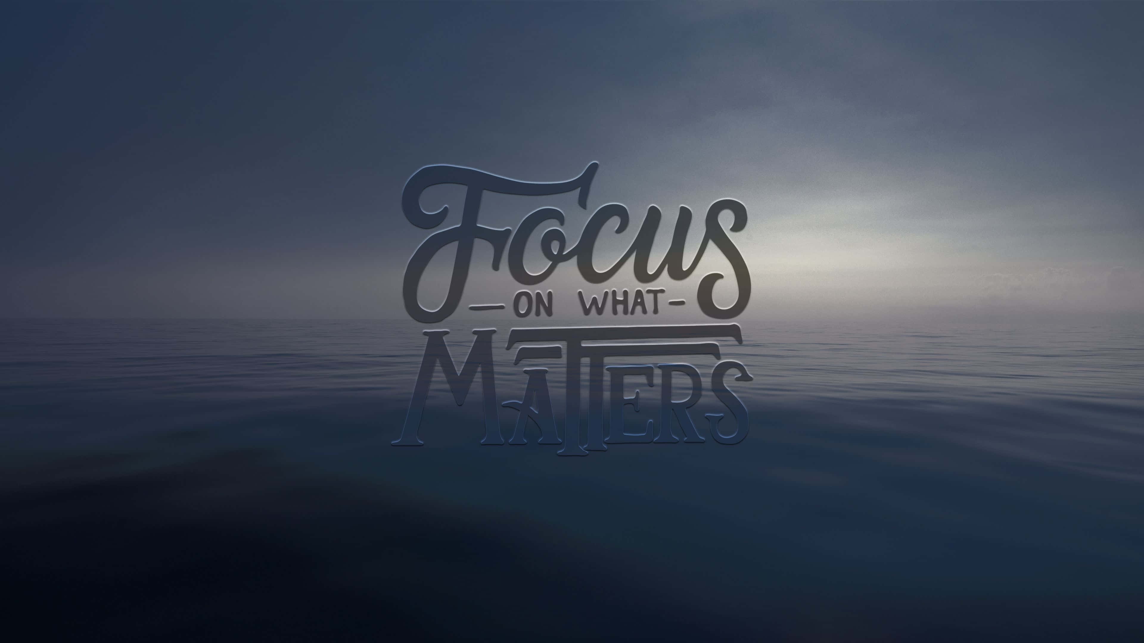 Focus 桌布 壁紙 — 優雅的金屬文字寫著「Focus on What Matters」，漂浮在平靜的海洋上，背景是憂鬱的黃昏天空。