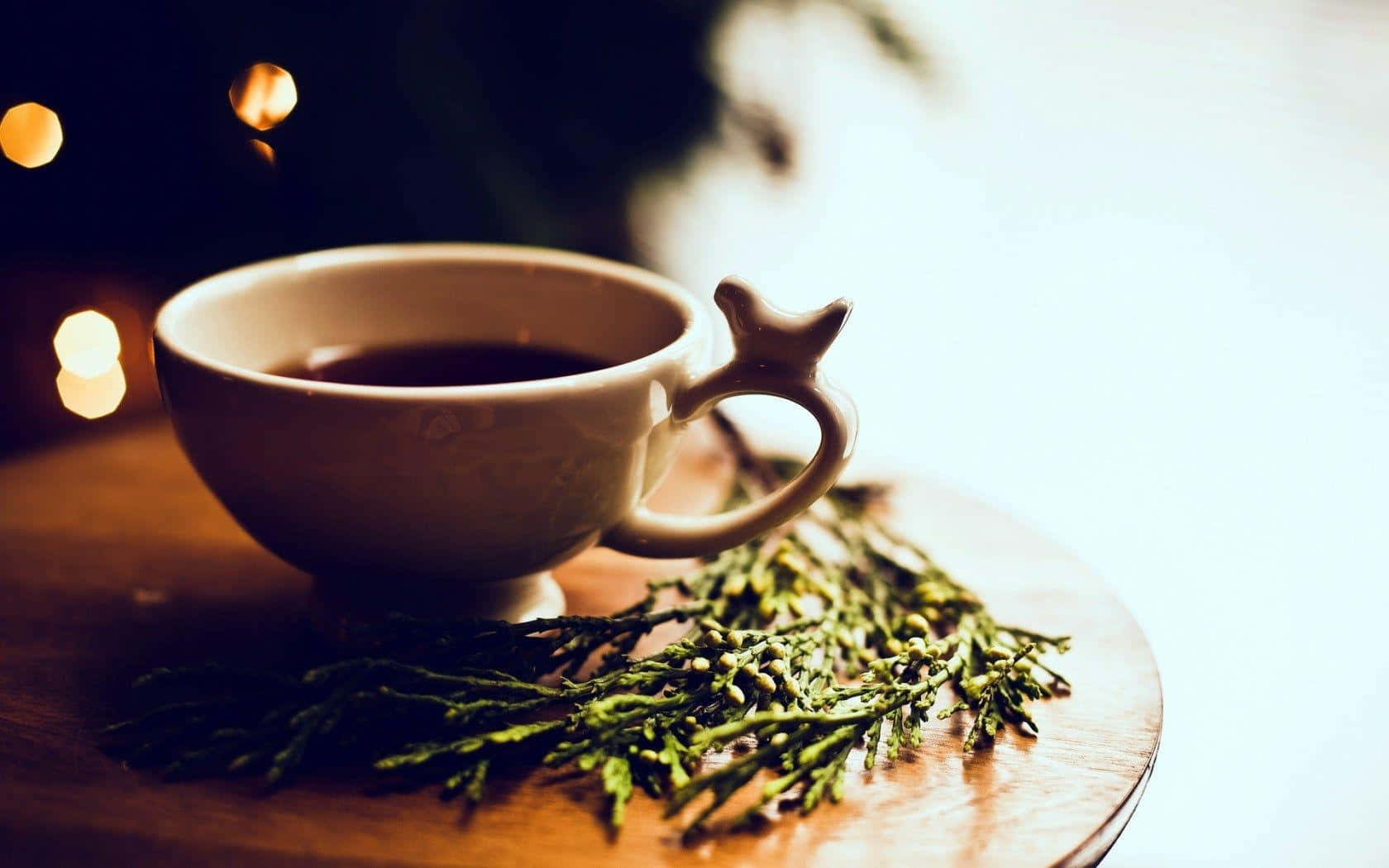 優雅茶杯：奢華品味 壁紙 — 一個帶有星形手柄的陶瓷杯放在木托盤上，旁邊有常綠枝葉，背景是柔和嘅散景燈光。