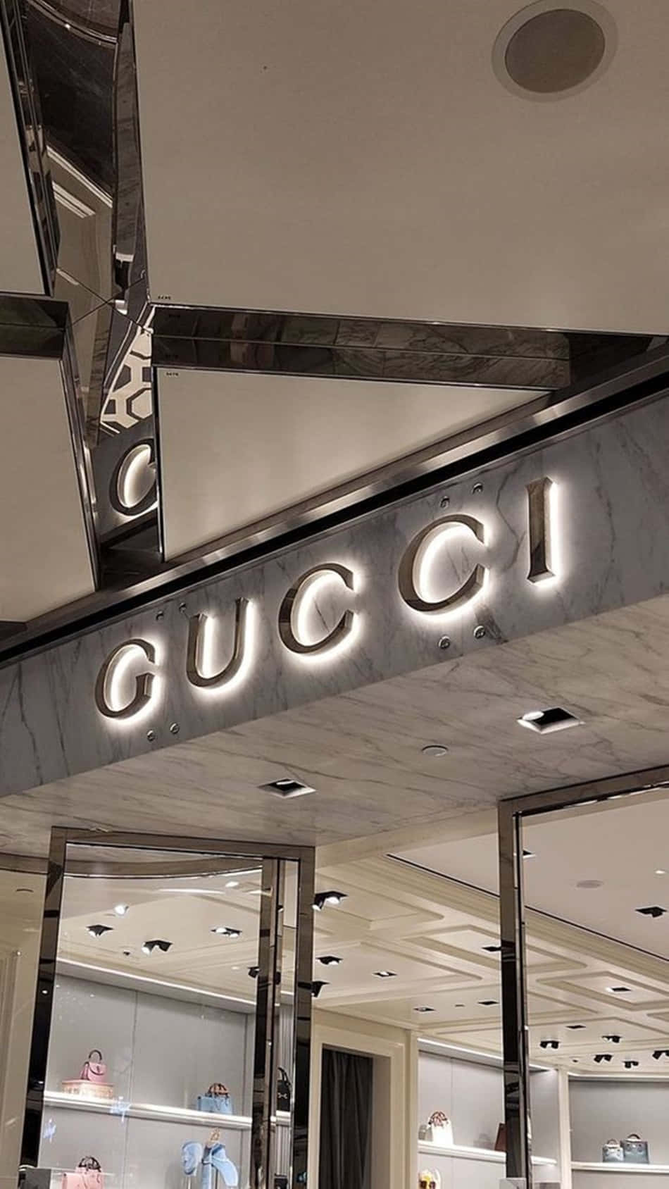 Gucci豪華時裝店入口，帶有發光招牌和鏡面天花。